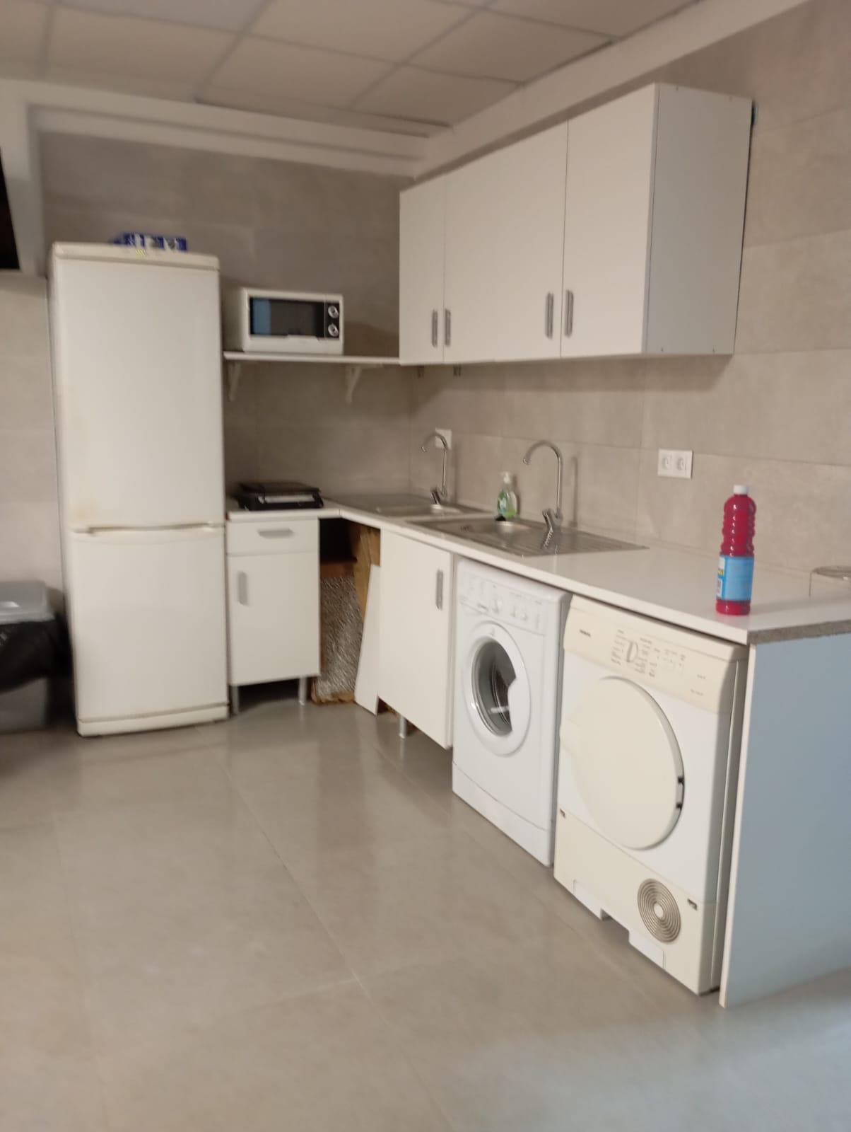 Cocina con nevera, microondas, lavadora y secadora